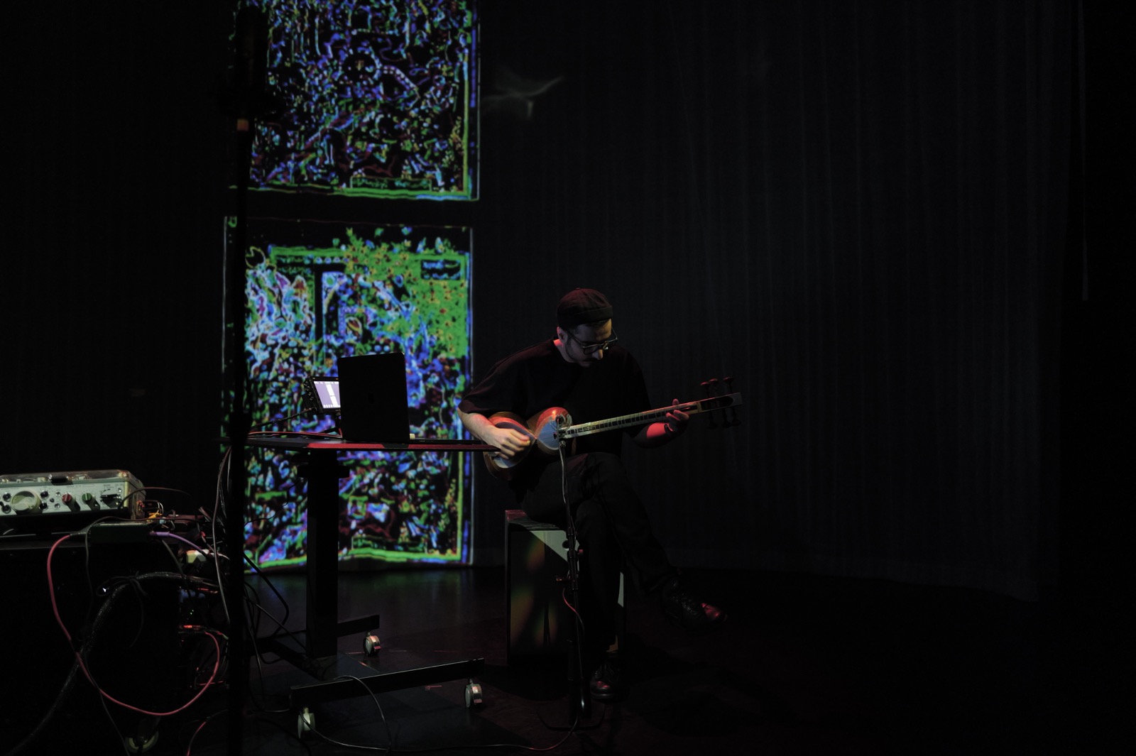The projected panels and performer on a darkened stage